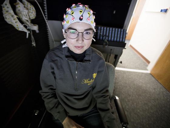 A student with an EEG cap on their head.