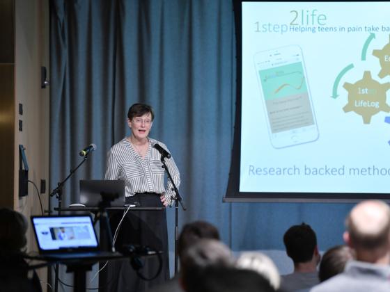 A professor makes a presentation in a business setting (not a classroom).