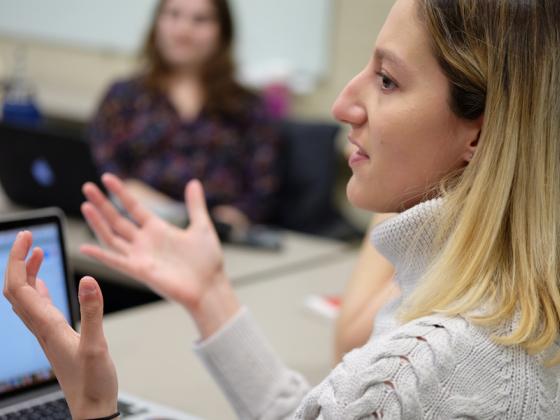 A student explains a point in a small group setting.