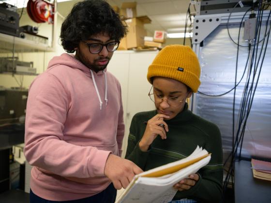 Two students review a document in a lab.