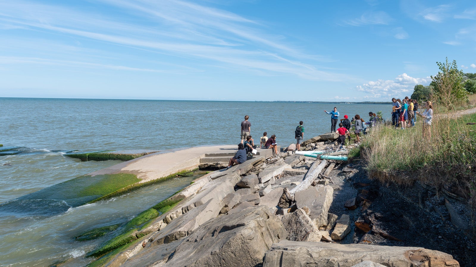 a group of students on rocks on a lake