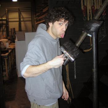 Adam makes a funny face while holding a wide paintbrush