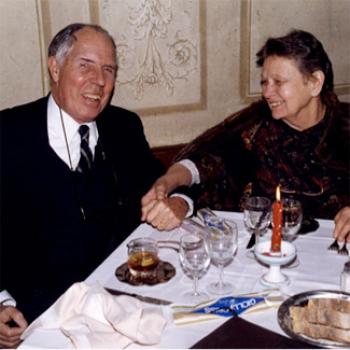 A couple enjoys a restaurant meal by candlelight
