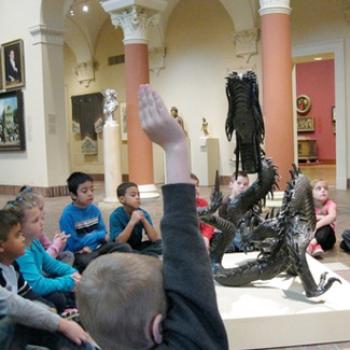 A grade school class learns about a sculpture at a museum