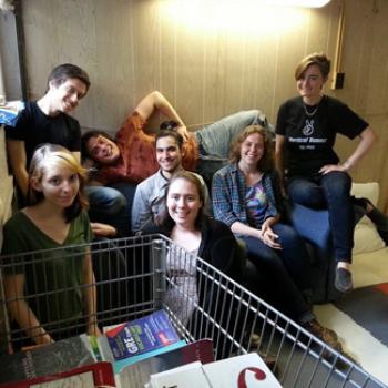 A group of friends with a shopping cart full of books