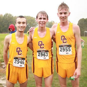 Three runners in rain-soaked cross country team uniforms