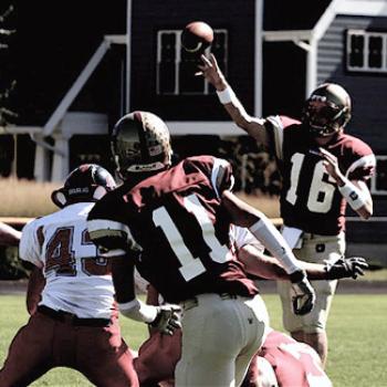 A quarterback releases the ball toward a receiver