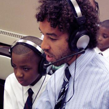 Wearing an audio headset, Jabali works with a couple of school-age boys