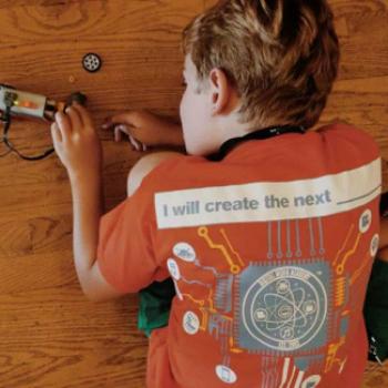Wering a shirt that reads 'I will create the next [blank space]', Lauren tinkers with a device