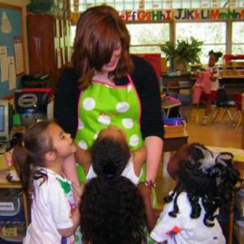 Mathilda receives hugs and smiles from young children in an elementary school classroom.