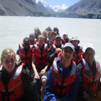 A group of people seated in a boat on a mountain lake.