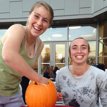 Rose and a friend have fun carving a pumpkin.