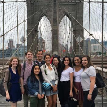 A group poses at a city bridge.