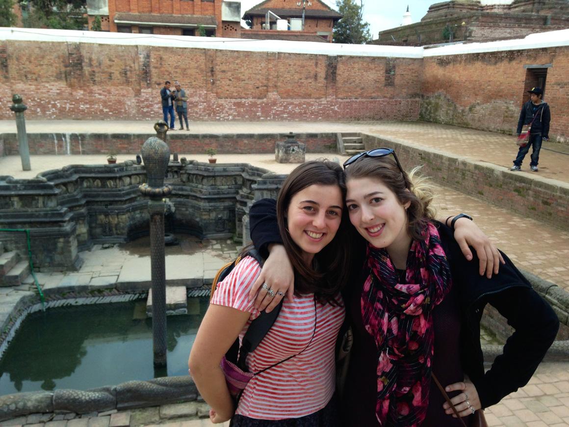 Two people pose at a fountain.