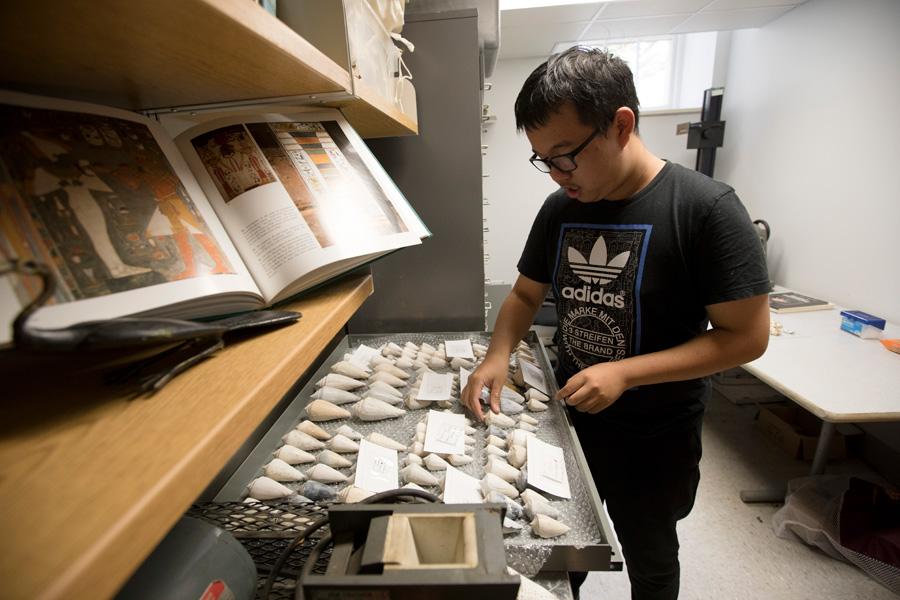 A student works with a tray of artifacts.