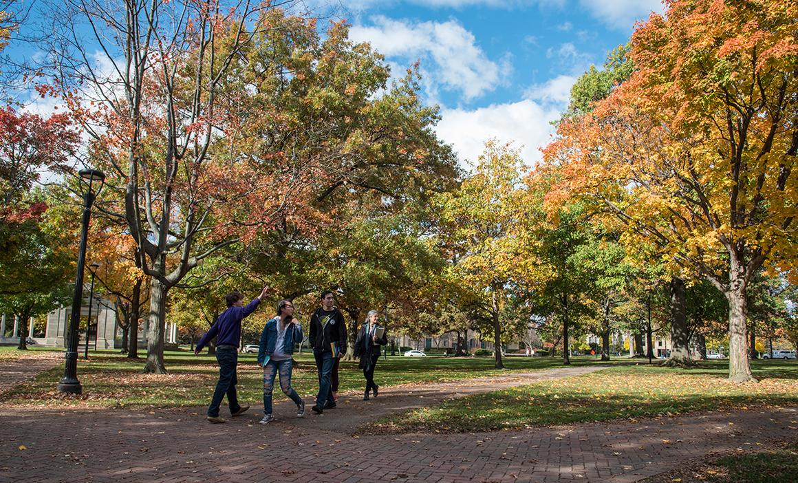A family takes a campus tour amid fall foliage