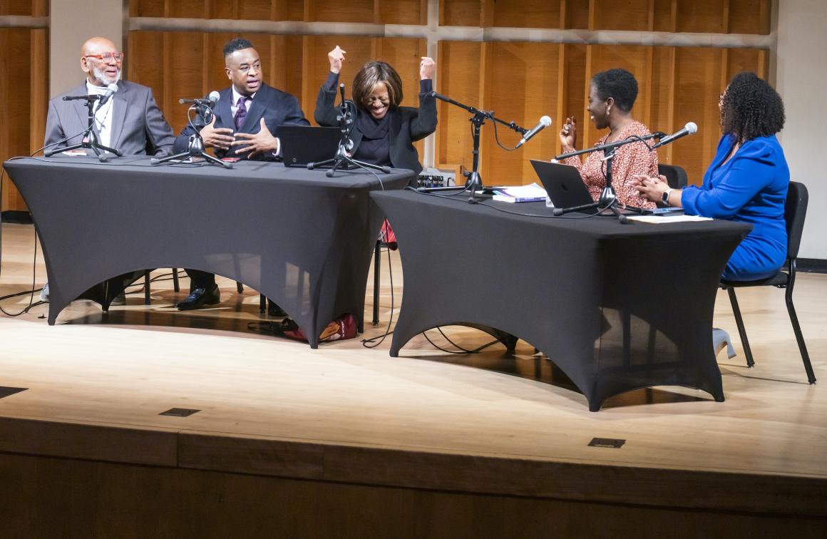 Six panelists hold a discussion on stage.