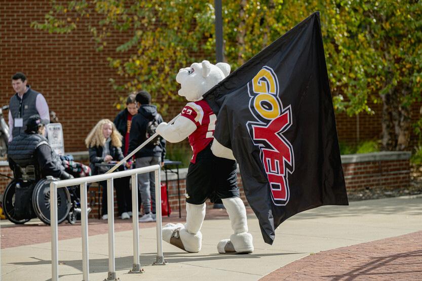 The mascot Yeobie, a white squirrel, carries a flag with the GoYeo logo on it.