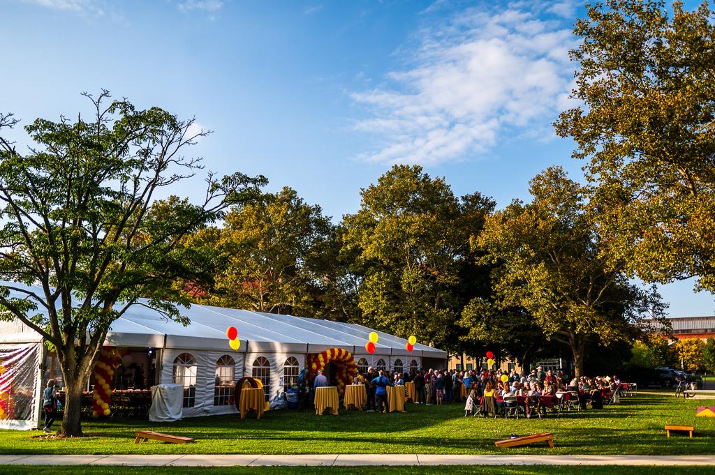 The Homecoming Reunion tent in Wilder Bowl, with a crowd of people gathered around it. The sky is blue.