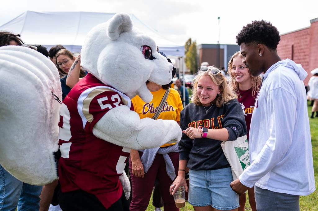 Oberlin students fist bumping the Oberlin mascot, Yeobie.