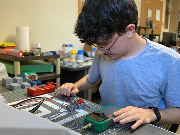 Otávio works on some electronic components.
