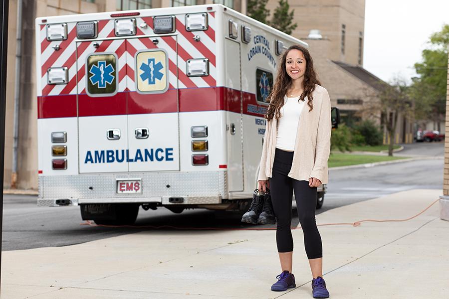 Student stands in front of an ambulance