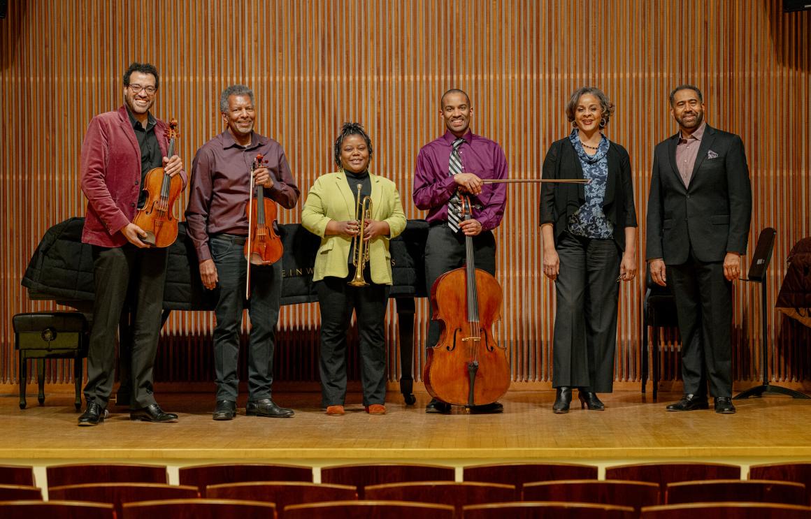 Musicians posing on the stage of Kulas Recital Hall after their concert.