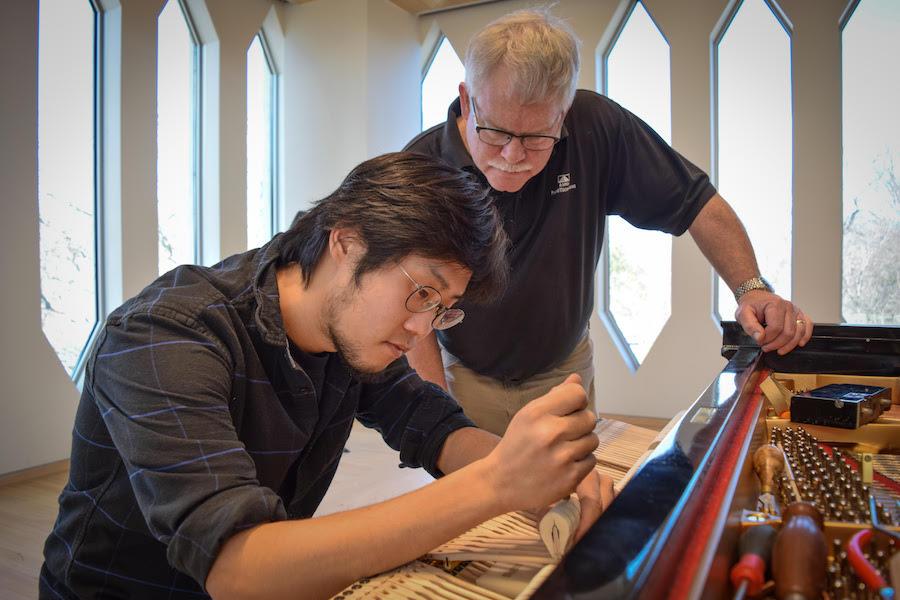 Teacher John Cavanaugh works with a piano technology student.