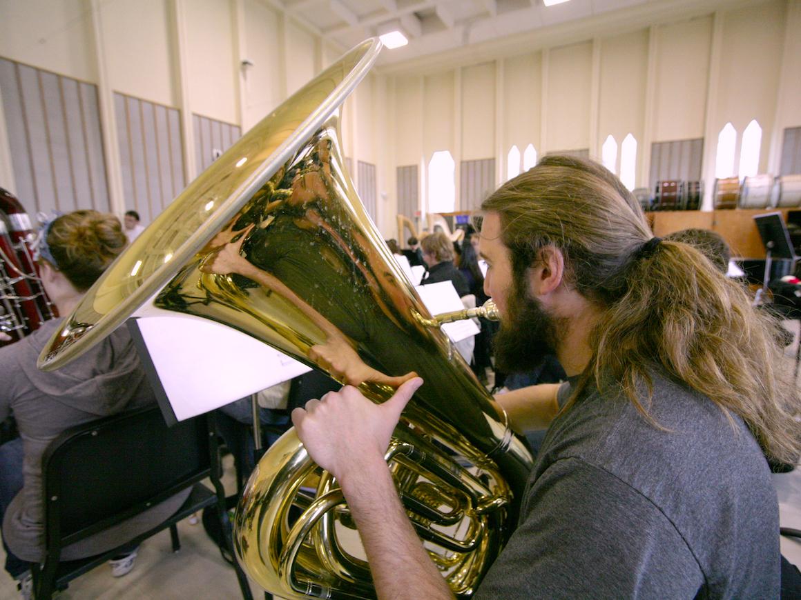 conservatory tuba student rehearses in one of large practice rooms.