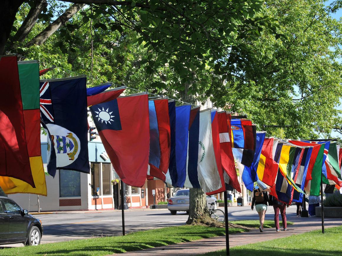 international flags hanging from poles along a main street.