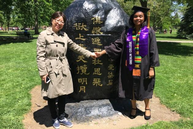 Fang Liu and a student in front of the rock on Tappan Square.