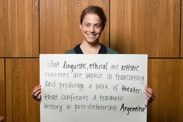 A student holding a sign that reads, "What linguistic, ethical, and artistic concerns are implicit in translating and producing a work of theater that confronts a traumatic history in post-dictatorship Argentina?