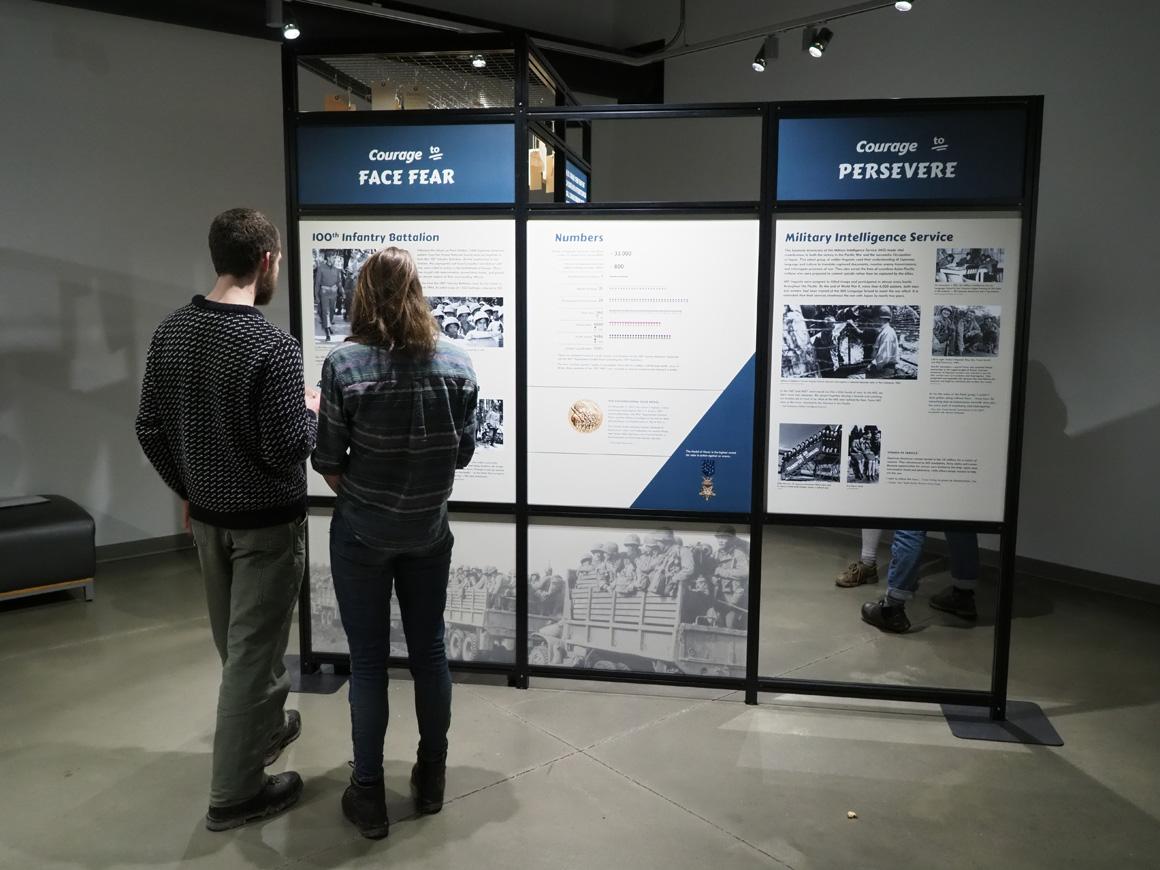 People view a poster at an exhibit.