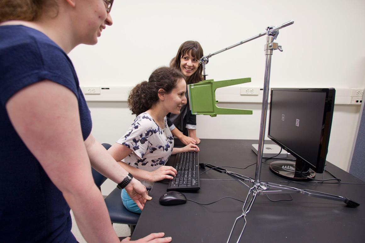 Students test a subject using visual stimuli on a computer screen.