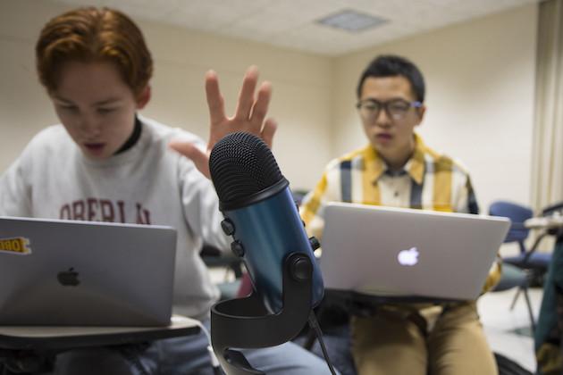 Two students recording a podcast in a classroom.
