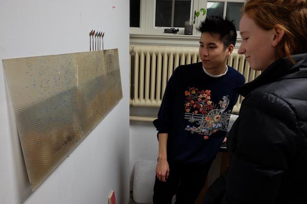 Two students looking at artwork.