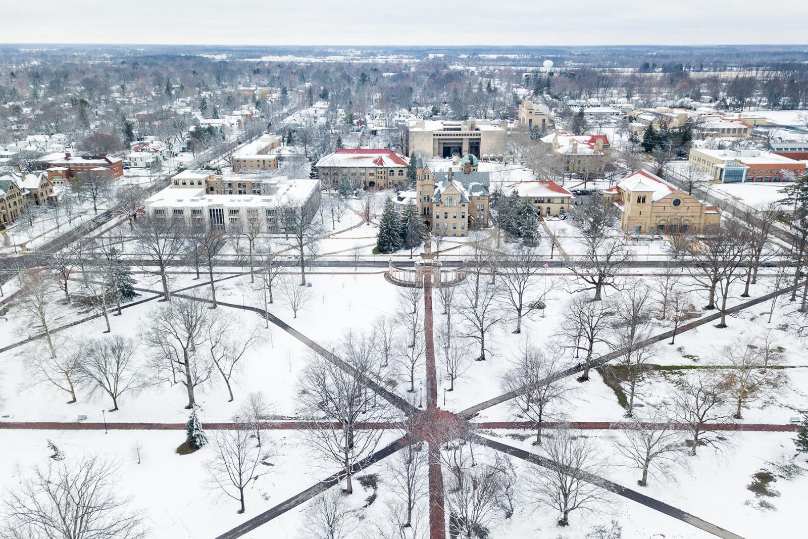 Aerial view of snowy campus during winter.