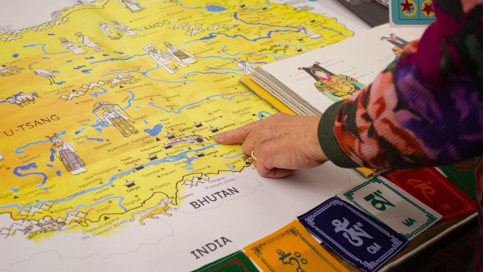 Hand pointing at colorful map of Bhutan