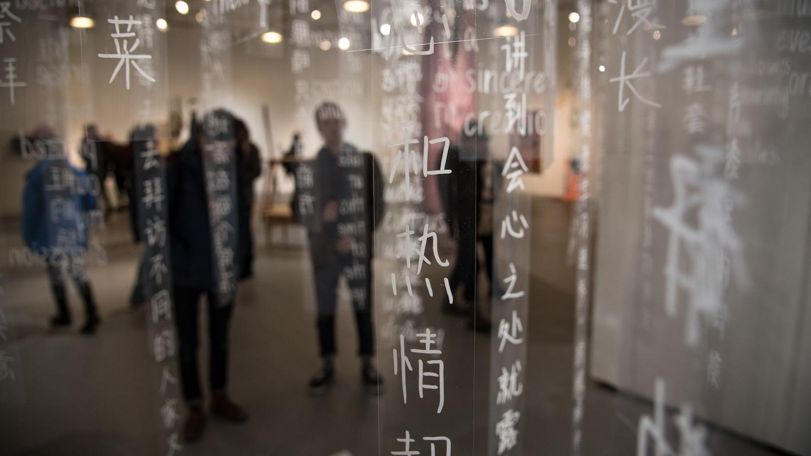 Students behind clear, long strips with Chinese writing in white letters.