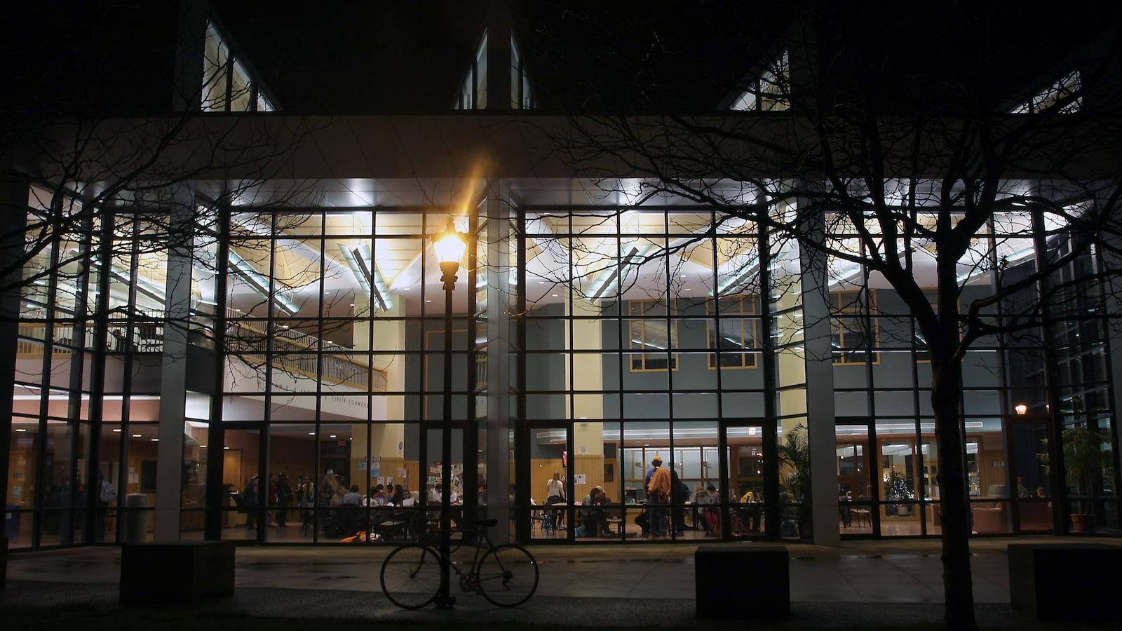 Students studying in the Science Center atrium at night.