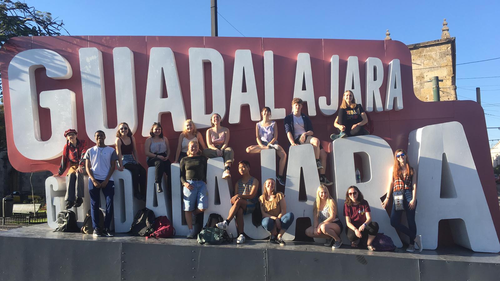 A group of students in front of a large Guadalajara sign.