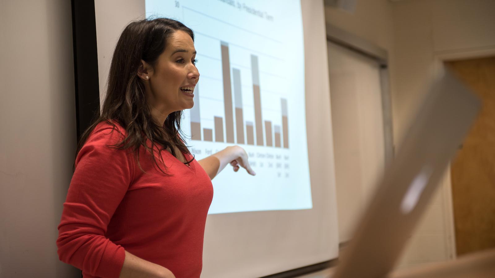 Professor Jenny Garcia pointing at a bar graph on the screen.