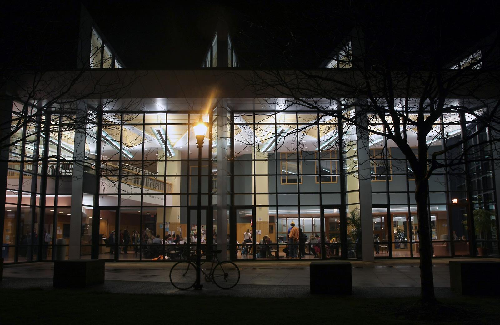A nighttime view looking into the busy, lit up atrium of the science center.