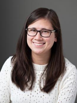 wearing white sweater and has long brown hair; Alex Wang.