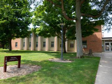 grassy area leading to the two story brick residence hall.