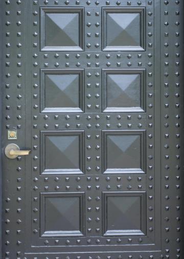 Eight panel door with square nail heads.
