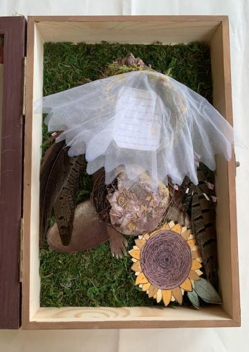 A box filled with netting and a paper sunflower