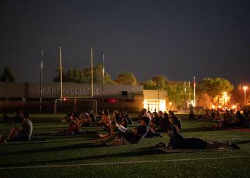 People watching a movie in a football field