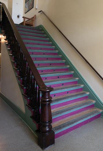 Purple staircase with wooden rails.