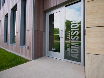 front entrance of admissions office with large glass door.